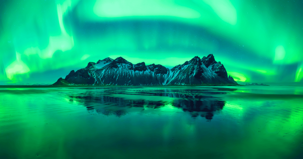 Aurora reflections on Stokksnes Black Beach in Iceland with Vestrahorn mountain. 5 Top destinations to visit in 2025. Everything travel.